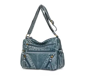 Detail view of vintage washed blue motorcycle bag with functional zippers and strap