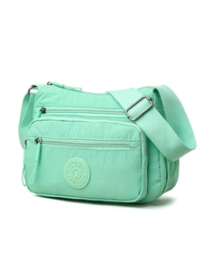 Detail of mint green nylon crossbody bag showing multiple zip pockets and brand logo