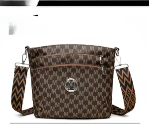 Detail of vintage crossbody bag featuring M-pattern leather and geometric wide strap