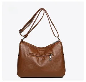Rear view of brown crossbody bag featuring back zipper pocket and adjustable strap