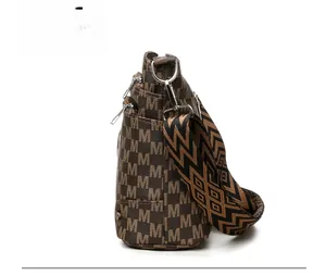 Side view of soft leather crossbody bag with M-pattern print and woven geometric strap