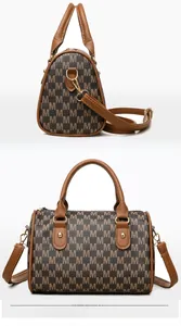 Detail of Boston bag featuring brown M-letter print and golden rivet hardware