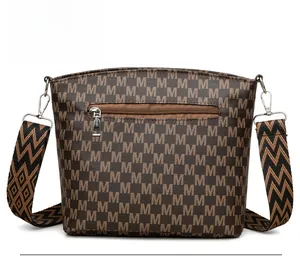 Close-up of the back zip pocket and geometric patterned strap on a brown bucket bag