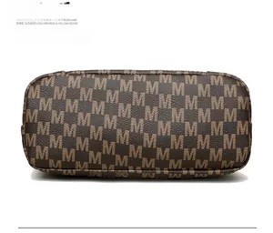 Detailed bottom view of soft brown faux leather shoulder bag with repeating M pattern