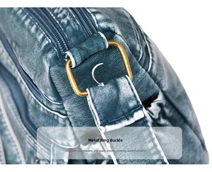 Detail of durable bronze metal hardware ring and soft blue washed leather bag strap