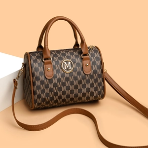 Retro Boston handbag with M-pattern jacquard and caramel leather straps in a front view