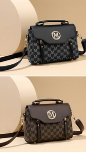 Close-up of retro satchel bags with M-pattern print and metallic round logo detail