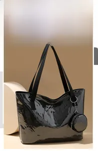 Detail of black glossy PVC tote bag with white text and round hanging coin purse