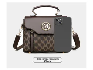 Classic retro crossbody bag size comparison with an iPhone showing brown leather and M logo