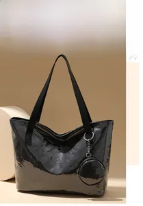 Macro shot of glossy black patent leather tote bag with round coin purse attachment