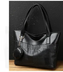 Dettaglio della borsa tote nera con patchwork di pelle testurizzata coccodrillo e lucertola