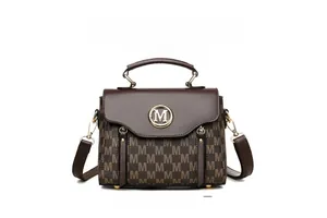 Detail view of brown monogram handbag with golden M logo and smooth leather flap texture