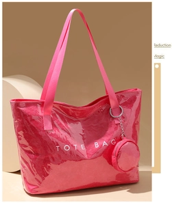 Macro shot of bright red patent leather tote bag with silver chain and round purse charm