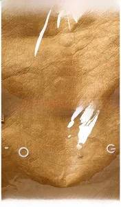 Macro detail showing brown leather texture and printed TOTE BAG logo on a modern tote