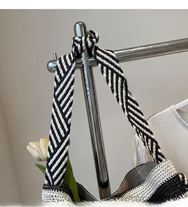 Close-up of black and white striped woven shoulder strap on a large tote bag