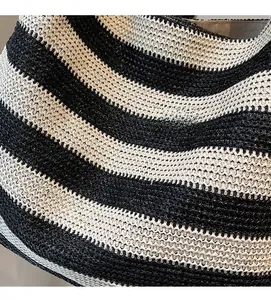 Close-up of black and white striped woven tote bag showing texture and knit details