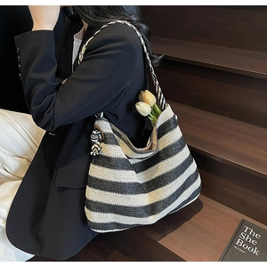 Detail of handwoven black and white striped tote bag showing paper straw texture