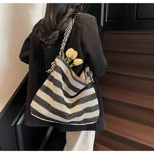 Detail of black and white striped woven tote bag showing texture and large hobo style
