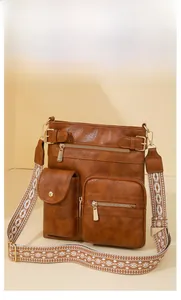 Brown faux leather shoulder bag with multi-zipper pockets and ethnic pattern strap