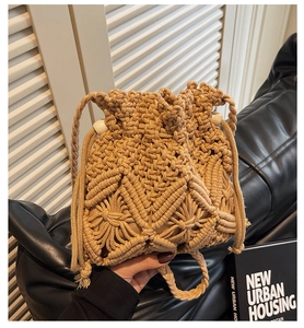 Close-up of handwoven beige straw bucket bag with intricate bead detailing and drawstring