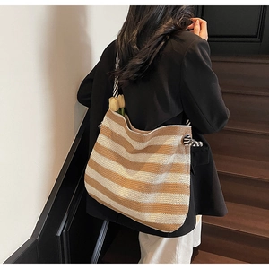 Detail of striped woven beach tote with soft cotton texture and decorative flowers