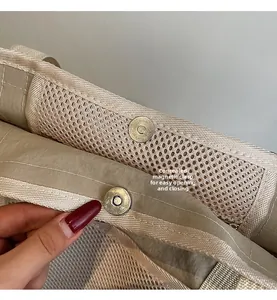 Detail van de onzichtbare magneetsluiting op de beige mesh reistas met vakken