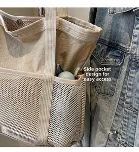 Detail van het zijvak van gaas op een beige draagtas met metalen drukknoopsluiting