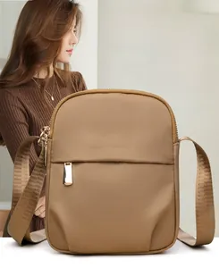 Close-up of brown nylon mini crossbody bag featuring a golden Danbaoly logo and zipper
