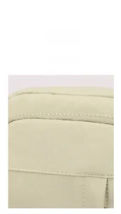 Detail of light green canvas messenger bag showing high-quality stitching and zipper