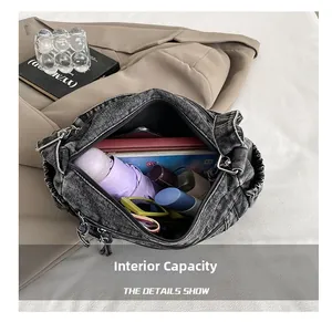Intérieur spacieux du sac hobo en jean rétro montrant une grande capacité pour iPad et objets