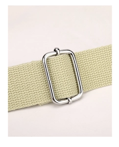 Detail of silver metal adjustment buckle on a beige canvas woven shoulder strap