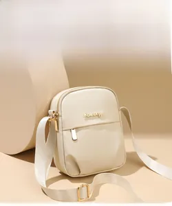 Vertical off-white nylon mini crossbody bag with gold zipper and adjustable shoulder strap
