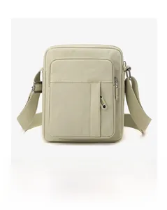 Detail view of canvas crossbody bag with multiple zip pockets and adjustable strap