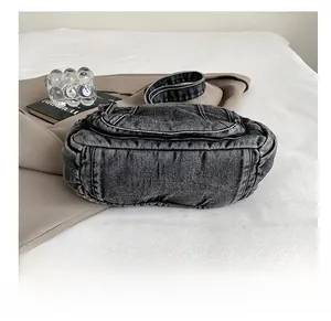 Détails des doubles coutures renforcées et de la base en denim durable du sac fourre-tout