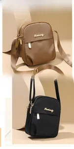 Detail view of khaki and black nylon crossbody phone bags with gold zipper and metal logo