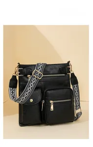 Detail of black pebbled leather bag with ethnic woven strap and golden hardware