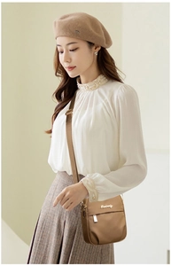 Detail of a dark khaki nylon crossbody phone bag with metal logo and adjustable strap