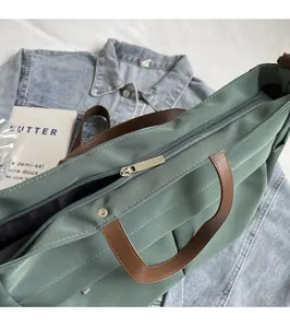 Détail du zip métallique argenté sur le sac fourre-tout en nylon vert foncé