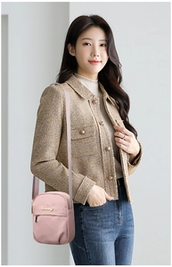 Detailed shot of a pale pink mini nylon crossbody bag with gold logo on a model