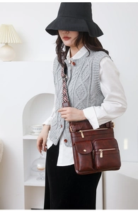 Detail of dark brown PU leather crossbody bag featuring multiple pockets and ethnic strap