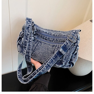 Détail du cabas en jean bleu vintage avec fermetures éclair et bandoulière
