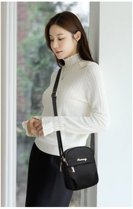 Detail of black nylon crossbody phone bag with gold zipper and Danbaoly brand logo