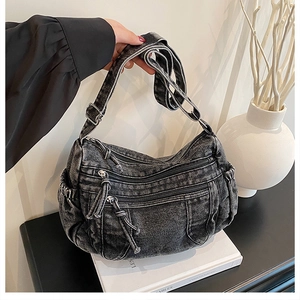 Vue détaillée du sac en jean délavé avec poches multiples et boucles argentées
