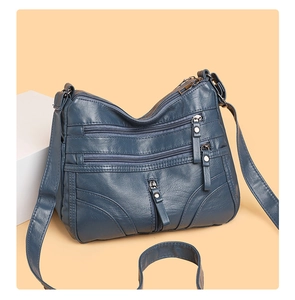 Detail of navy blue soft leather crossbody bag with multiple functional zip pockets
