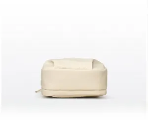 Detail view of the reinforced base stitching on a stylish beige nylon crossbody bag