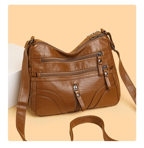 Detailed view of dark brown faux leather crossbody bag with multiple zip pockets