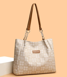 Détail du sac cabas à carreaux avec écusson logo en cuir et bandoulière chaîne