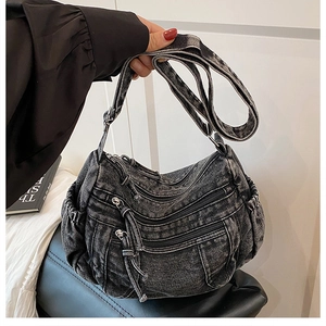Détail du sac en jean gris foncé avec trois fermetures éclair et plis latéraux