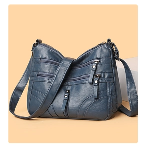 Detailed macro view of dark blue pebbled faux leather with multi-layer zipper pockets