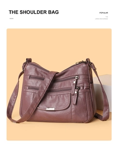 Macro detail of purple soft leather shoulder bag showing multi-zip pockets and texture
